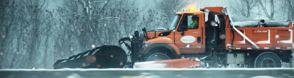 Vermont Agency of Transportation Snow Plow Truck plowing a snowy road.