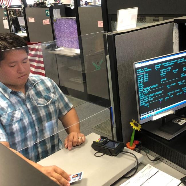 Man renewing license at counter